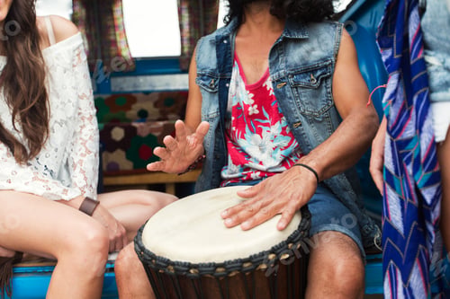 Preview: close up of hippie friends playing tom-tom drum
