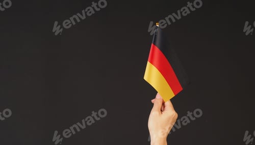 Preview: Hand is hold german flag on black background