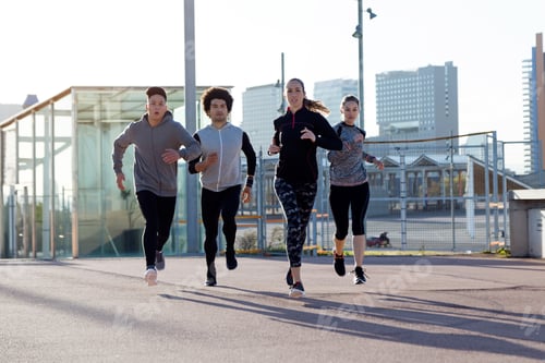 Preview: Portrait of group of friends running in the city.
