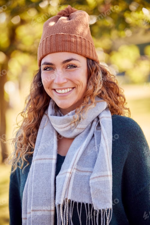 Preview: Portrait Of Smiling Young Woman Wearing Hat And Scarf In Autumn Park