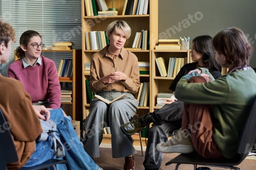 Preview: Adult Woman Leading Group Therapy Session with Diverse Teenagers