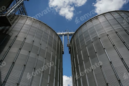 Preview: Industrial silos against a blue sky with clouds