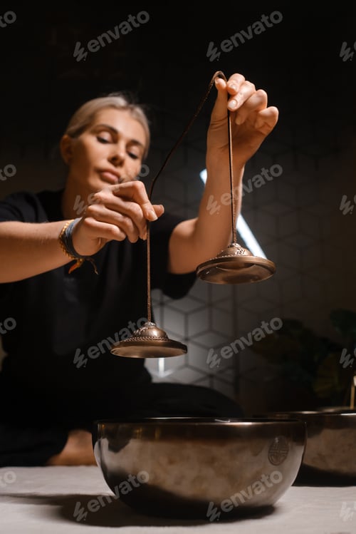 Preview: Practicing mindfulness and meditation with singing bowls in a serene indoor setting during the