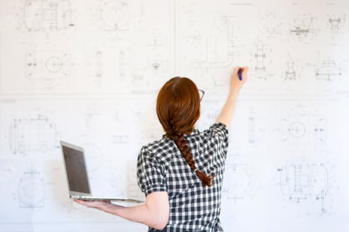 Preview: Young woman engineer draw on the drawings and holds a laptop. the working process