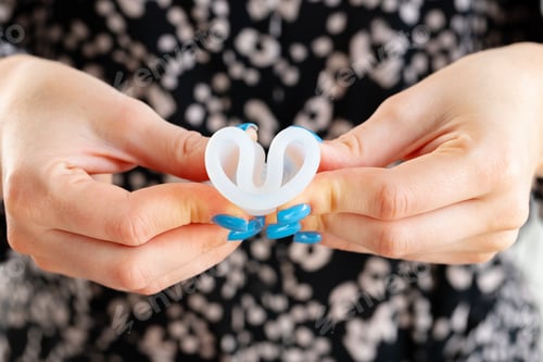 Preview: Woman folding menstrual cup in hands close up
