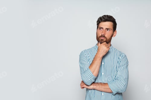 Preview: Portrait of pensive bearded man on grey background. Space for text