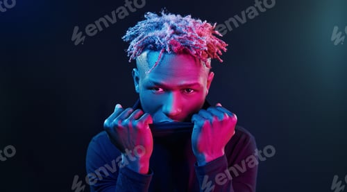 Preview: Futuristic neon lighting. Young african american man in the studio