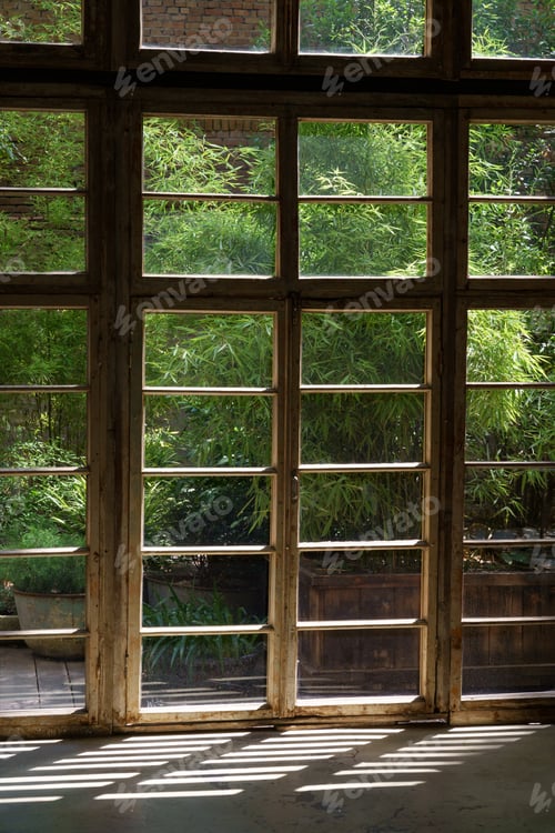 Preview: Big wooden frame of panoramic window of cottage house overlooking summer garden with lush plants