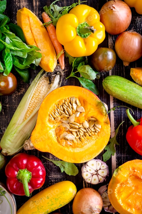 Preview: Fresh vegetables scaterred on a rustic dark textured table. Autumn background