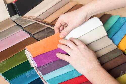 Preview: Man hand chooses samples of colored fabric on table close up
