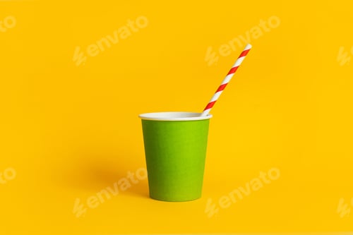 Preview: Green paper cup with striped paper straw on yellow background, biodegradable disposable tableware