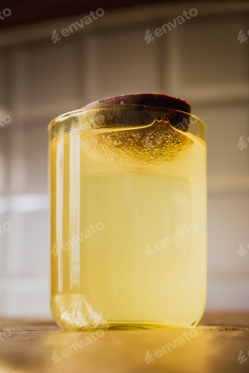 Preview: A bright yellow cocktail with ice in a rocks lowball glass garnished with passion fruit