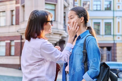 Preview: Talking mom and teenage daughter outdoors, on city street