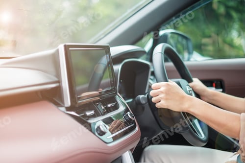 Preview: woman driver driving a car on the road, hand controlling steering wheel