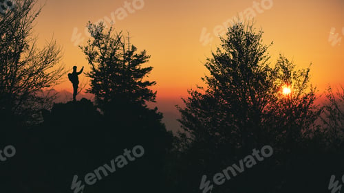 Vista previa: A person in silhouette photographs the sunset