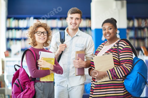 Preview: Happy students with books in library