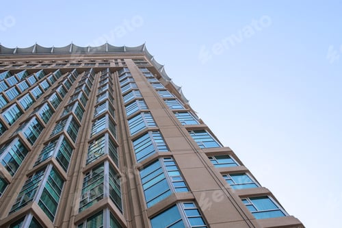 Preview: Low Angle Perspective Of Towering Modern Skyscraper With Tan Facade And Rows