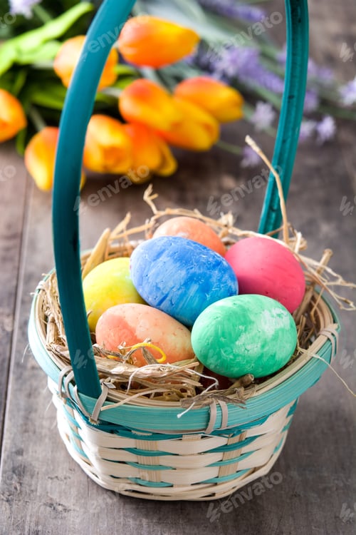 Preview: Colorful easter eggs in basket with spring flowers celebrating easter holidays