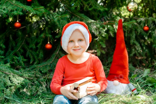 Preview: Child kid waiting for Christmas.boy opening gift box near fir tree.winter festive holidays.New Year