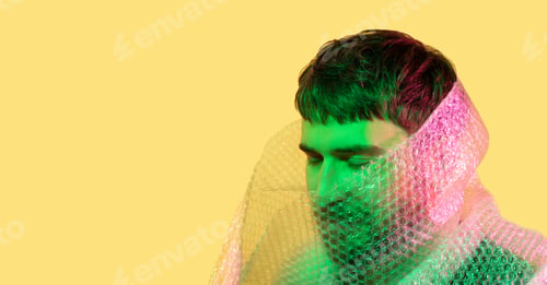 Preview: Plastic reuse. Environmental protection. Art portrait man's head wrapped in bubble wrap on yellow