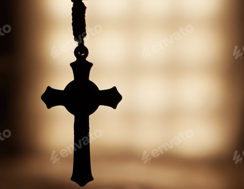 Preview: Close-up sho of a silhouette of a Rosary with a blurry background