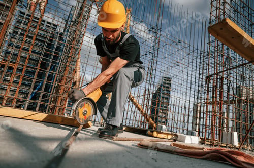 Preview: Using grinding machine to cut metal pieces. Man in uniform is working on the construction site