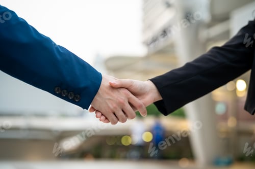 Preview: Close up of businessman and woman making handshake outdoors in the city.