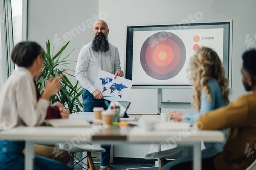 Preview: Marketing executive leading business meeting with world map and target market presentation