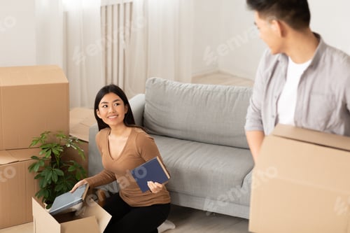Preview: Happy asian man and woman unpacking in dorm