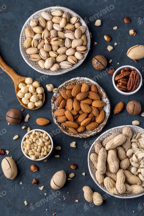 Preview: Assorted nuts in plates on a blue background top view