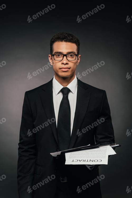 Preview: african american businessman holding documents on dark background