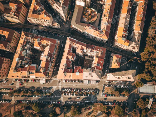 Preview: Aerial view of roofs of italian city town in fall season with car parking in the street