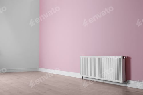 Preview: Modern radiator on color wall indoors. Central heating system