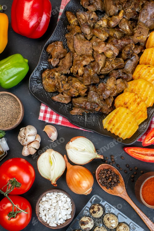 Preview: top view tasty kebab with potato on platter black pepper in small bowl onions tomatoes on dark