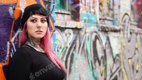 Preview: young urban woman leaning against grafitti wall