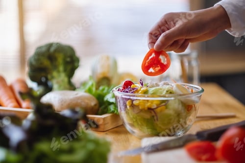 Preview: Closeup image of a female chef cooking a fresh mixed vegetables salad in kitchen