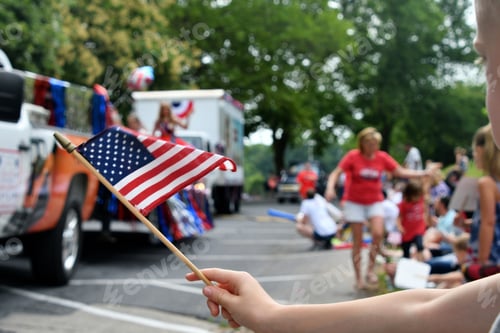 Preview: Watching the Independence Day Parade on the 4th of July while waving an American flag.