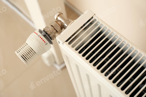 Preview: Heating radiator with thermostat near wall indoors, closeup