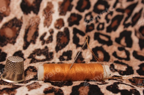Preview: Spool of Tan Thread on Leopard Print Fabric