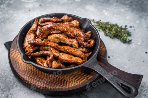 Preview: Delicious glazed teriyaki beef in a skillet. grey background. top view