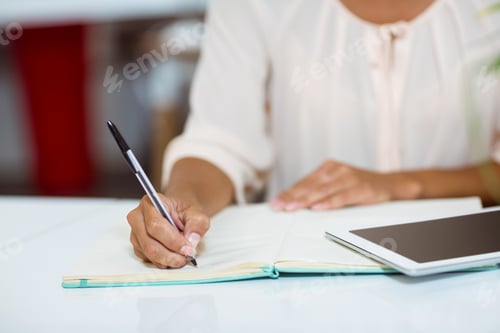 Preview: Business executive writing on diary