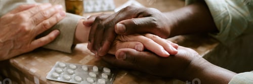 Preview: Senior Multiethnic Couple Comforting Each Other While Holding Hands at Table