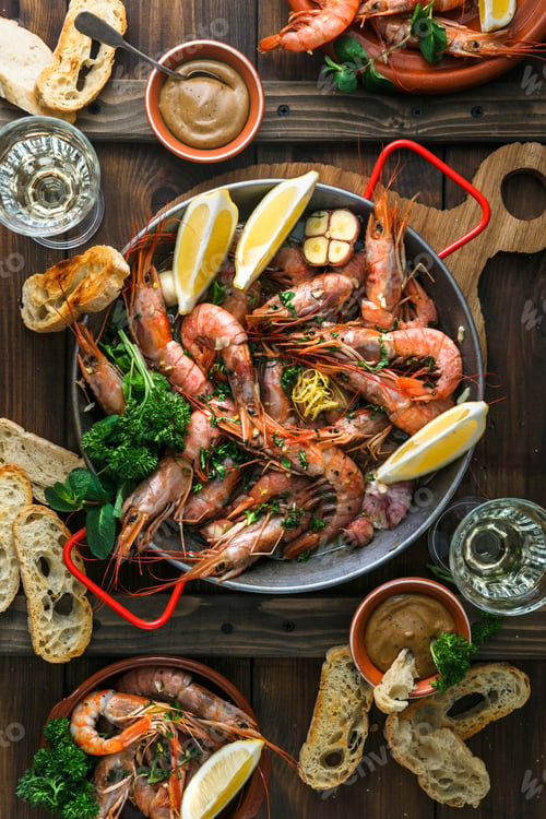 Preview: Paella pan with roasted tiger shrimps and many dishes, bread and wine