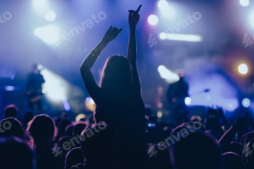 Preview: Silhouette of a woman with raised hands on a concert