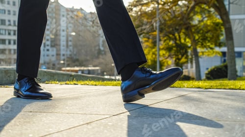Preview: Legs of a businessman in fashionable shoes walking outdoors. Business concept. businessman's shoes