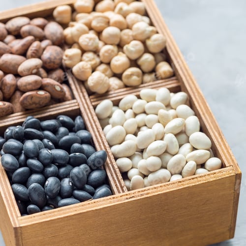 Preview: Different kinds of beans in a wooden box on concrete background, square