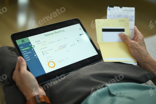 Preview: Closeup unrecognizable man using digital tablet and credit card for online payments.