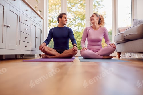 Preview: Couple Sitting On Mats At Home Doing Yoga Exercises Together