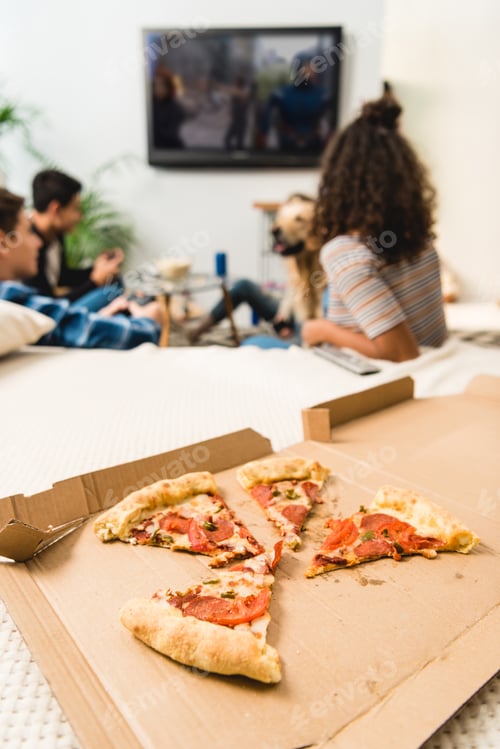 Preview: multicultural teens playing video game with pizza on foreground