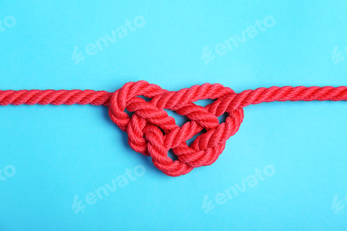 Preview: Heart made of red rope on color background, top view